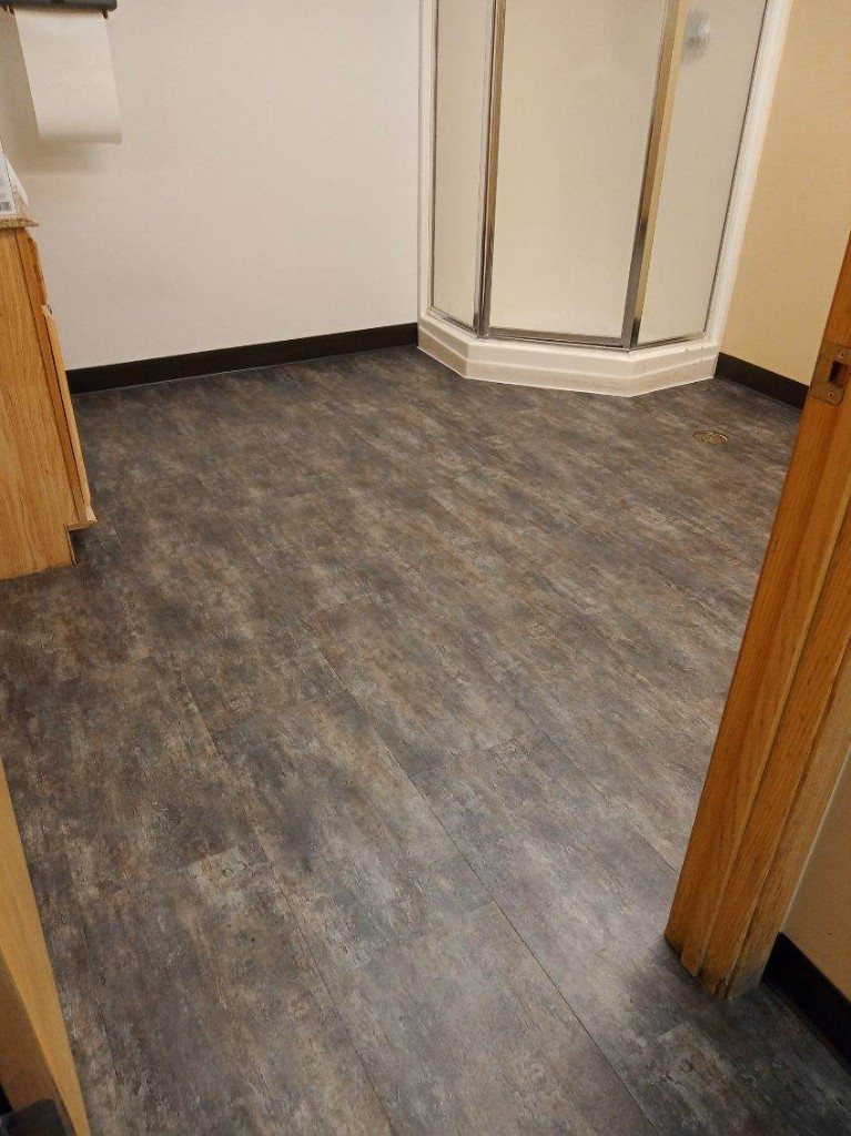 Stone look LVT in a bathroom around a shower